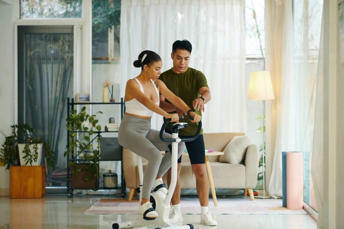 Personal trainer helping a beginner client at home